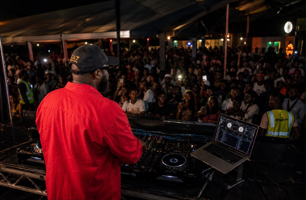 Bammixx performing behind a DJ booth to a packed crowd